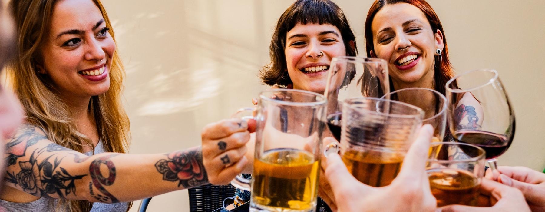a group of women holding glasses of beer